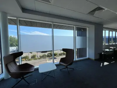 Corner office with frosted privacy band applied along the full-height window glazing