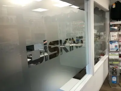 Disking shop glass partition with frosted privacy film and cut-out 'DISKING' lettering