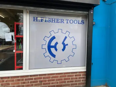 H. Fisher Tools shopfront window frosting with blue gear logo and shop name