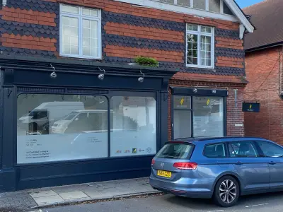 G20 Group shopfront windows frosted with services listing; blue VW estate parked outside