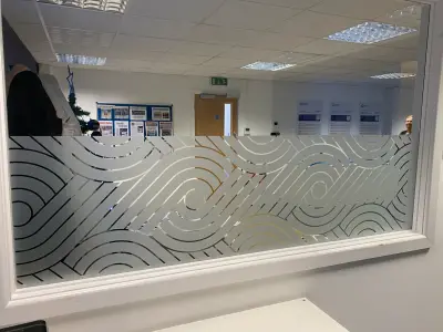 Office glass partition with frosted swirling wave-pattern window film