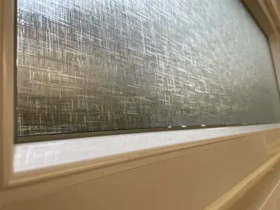 Close-up of linen-texture frosted privacy film applied to a window