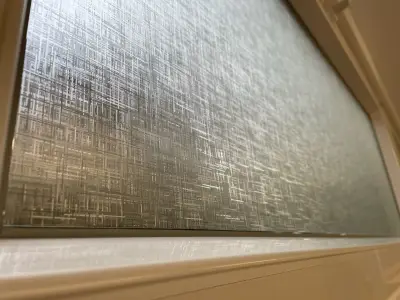 Linen-texture frosted privacy film covering a window pane