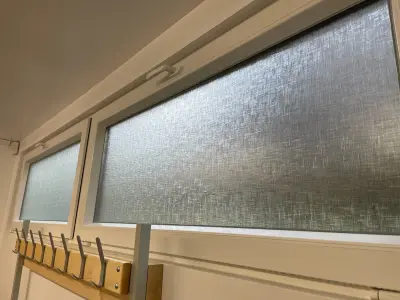 Linen-texture frosted film on high-level windows above a coat rack