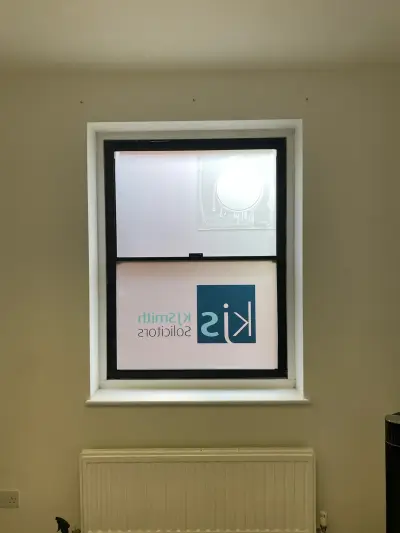 KJ Smith Solicitors logo on frosted privacy film covering an interior window