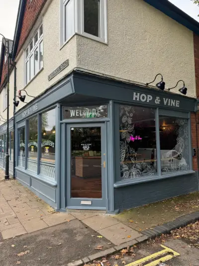 Corner Hop & Vine bar with fascia signs, welcome sign and Fine Wines window lettering