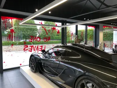 Black McLaren P1 in showroom with red blood-splatter Halloween No One Leaves window graphics