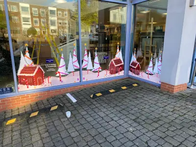 Auction house windows with painted gingerbread-house and Christmas-tree festive window graphics