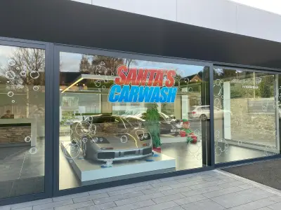 McLaren Petersfield showroom window with Santa's Carwash bubble graphics and silver supercar