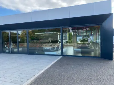 McLaren showroom windows with red blood-splatter and Scream mask Halloween graphics; Porsche 935