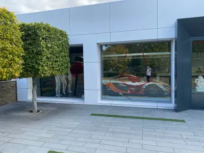 McLaren showroom window graphic of an orange and white McLaren racing car livery