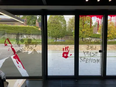 Showroom windows with bloody-knife, handprint and Do You Like Scary Movies Halloween graphics