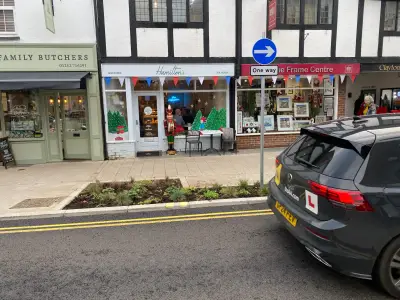 Farnham shopfronts including Hamilton's tea house with festive window graphics; black VW learner car