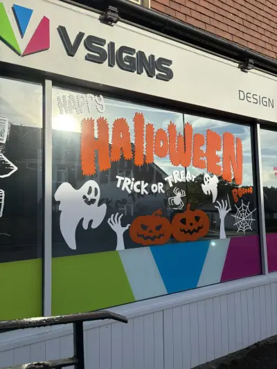 VSigns window with Happy Halloween graphics of ghosts, pumpkins and cobweb, backlit by sun